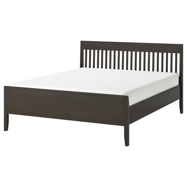 IDANÄS bed by IKEA: sleek dark brown wooden frame with vertical slats and tapered legs holding a white mattress. Elegant and sturdy design.