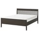 IDANÄS bed by IKEA: sleek dark brown wooden frame with vertical slats and tapered legs holding a white mattress. Elegant and sturdy design.