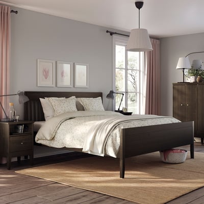 Bedroom with IDANÄS bed, beige bedding, nightstands, lamps, rug, curtains, art.