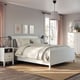 Modern white bedroom with IDANÄS bed, patterned bedding, nightstands, lamps, rug, curtains, and artwork.