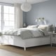 Modern white bedroom: large bed, grey bedding, sleek nightstands, stylish pendant light. Calm and minimalist design.