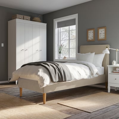 Modern cosy bedroom with beige bed, dark grey wall, white furniture, & art.