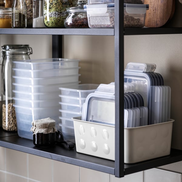 Black shelf with clear 365+ IKEA containers, lids, and jars.