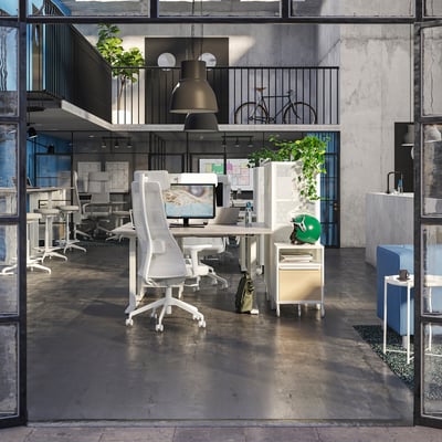 Modern open-plan office with ergonomic chairs, glass partitions, stylish lighting, and a bicycle.