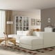 Modern living room with large white sectional sofa, coffee table, decor