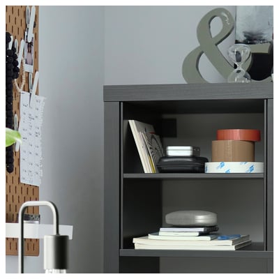 Modern grey shelf unit organised with books, boxes, and a lamp. Wood and metal design with grey finish.