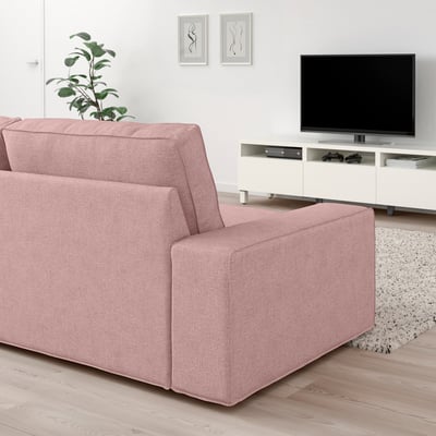 Modern living room with large pink KIVIK sofa, wooden floor, white tv stand, and green plant.