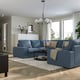 Modern living room with KIVIK blue sectional, wooden floor, large windows, and spherical pendant light.