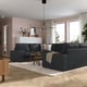 Modern living room with KIVIK sectional, cushions, wooden tables, windows, sideboard, patterned rug, and hanging lamp.