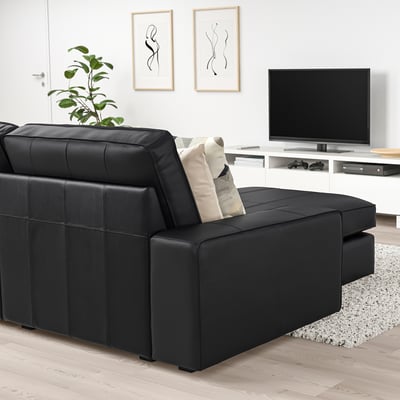 Modern living room with KIVIK sofa, art prints, tv, plant, and minimalist decor.