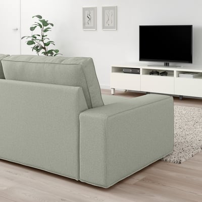 KIVIK sofa in light green, low-profile, spacious, with armrests, positioned near tv stand, modern, cosy living room setup.
