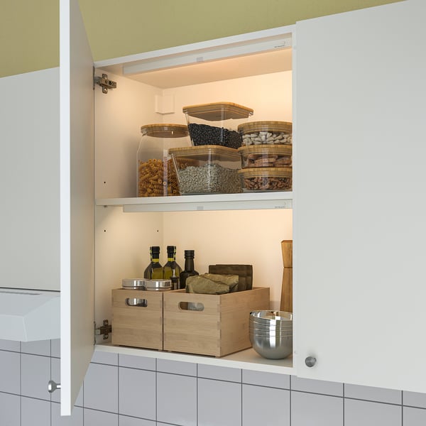 Kitchen storage with automatic led lights. Shelves hold jars of food. Wooden box and bottles below. Soft glow lights up dark spaces.