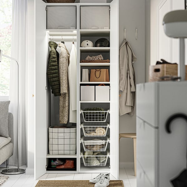Open closet with organised clothes, accessories, and shoes. Baskets on right, hanging garments and folded clothes on left.