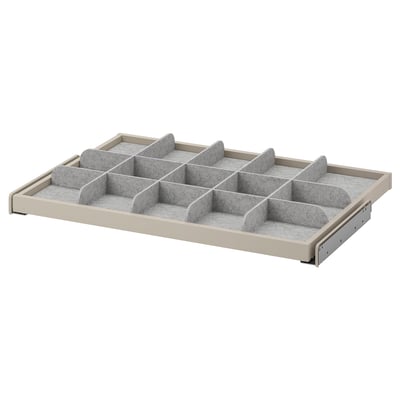 A KOMPLEMENT beiged organiser tray with multiple grey compartments for storage. It a pull-out design for easy access.