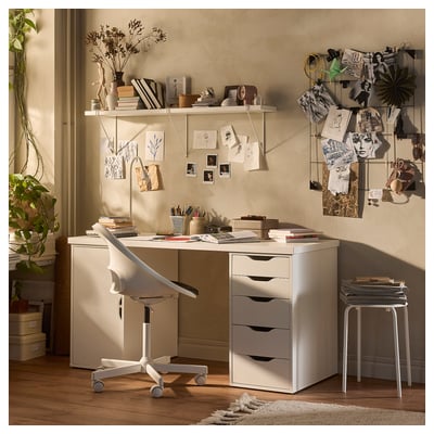 Cosy home office with white LAGKAPTEN desk, shelves, and chair. Decorated with plants, art, and inspiration boards.