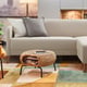 Modern living room with LINANÄS light grey sofa, grey cushions, woven storage ottoman, colourful rug, and wooden cabinet.