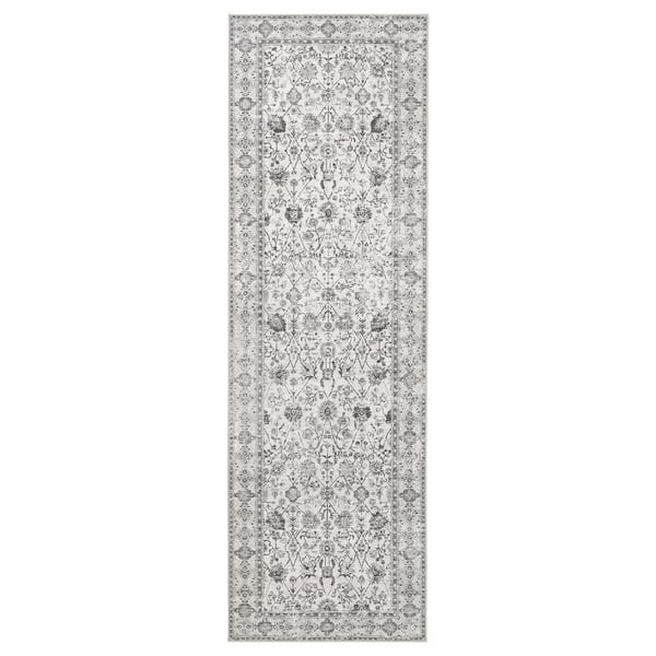 Long, grey, rectangular runner rug with intricate floral patterns in black and white, made from recycled polyester.