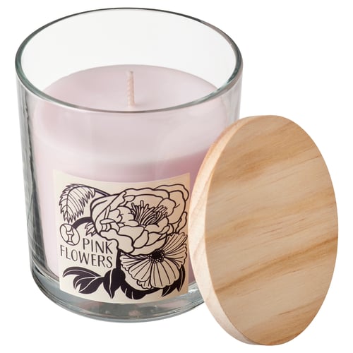 Pink flowers scented candle in clear glass jar with wooden lid, floral label, cylindrical shape.