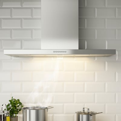Modern kitchen with stainless steel range hood. Hood led lighting and grease philtres. Extracted fumes efficiently.