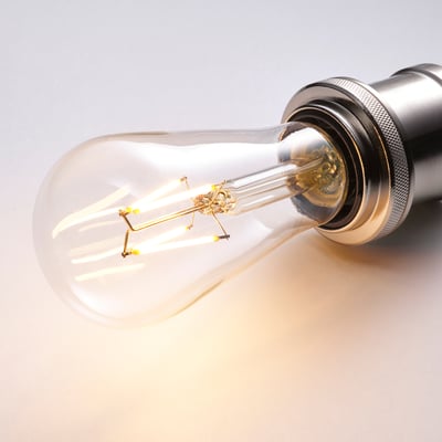 Close-up of a vintage-style led bulb, glowing warm light.