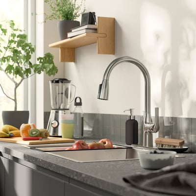 Modern kitchen with stainless tap, grey counter, wooden shelf, blender, and fresh fruits.
