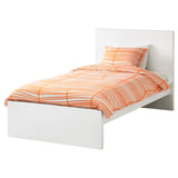 A white MALM bed with bright orange bedding, showcasing a modern design with clean lines and a high headboard.