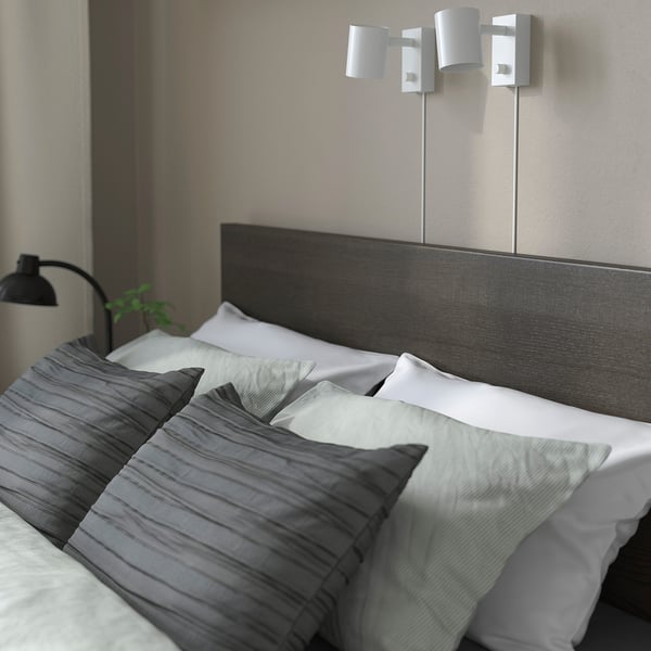 Modern bedroom with MALM bed, high headboard, crisp linens, and sleek wall lamps.