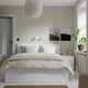 Serene bedroom: MALM bed, nightstands, floral light, black-and-white art, green plant, door, window.