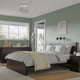 Modern bedroom featuring MALM dark brown bed with white linens, wooden drawers, glass pendant lights, and a green accent wall with a large window.
