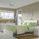 Modern bedroom with white MALM bed, green bedding, storklinta nightstands, nature view window, cosy setup.