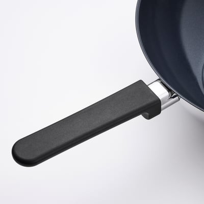 Wok with black phenolic handle and stainless steel parts. Non-stick surface, suitable for various hobs.