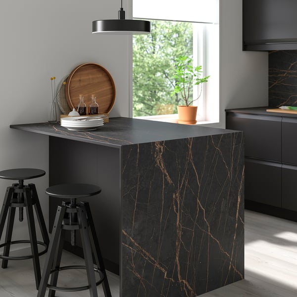 Modern kitchen with sleek black MÖCKLARP marble island and gold veins, surrounded by black stools.