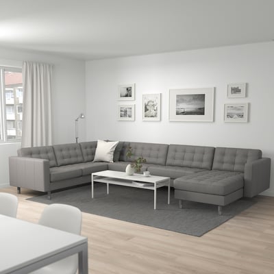 Modern living room with large grey MORABO sectional sofa, sleek coffee table, art wall, and wooden floor.