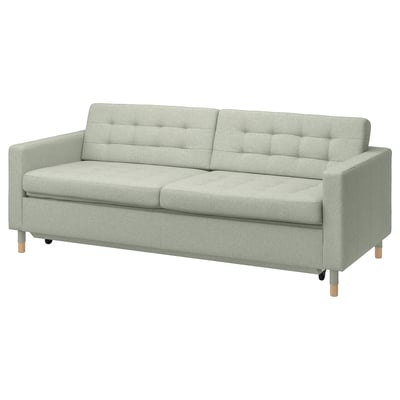 Modern sofa with tufted back, wooden legs, light grey fabric. Upholstered seat, clean lines.