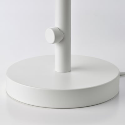 Modern lamp with round white base and vertical support, high-quality finish.