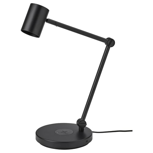 A black NYMÅNE lamp with adjustable arm, modern design, combining wireless charging and usb port for convenience.