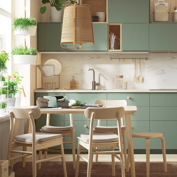 Modern kitchen with green cabinets and stainless-steel dish drainer ORDNING.