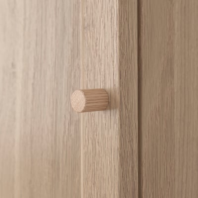 A wooden door with a cylindrical doorknob. The wood has natural grain visible, giving it a fine, quality finish.