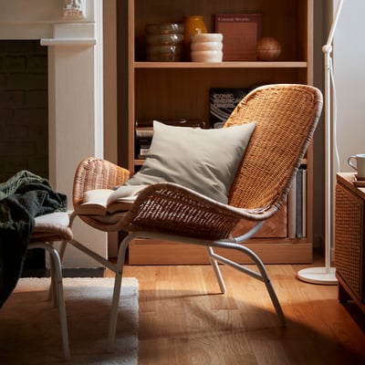 Natural rattan wicker chair with off-white cushion in cosy room.