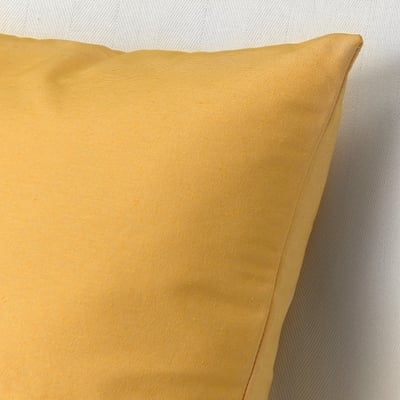 A mustard yellow cushion close-up, soft texture, natural fibres.