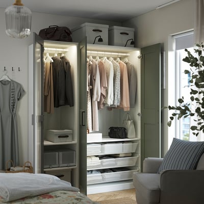 Mirrored wardrobe with organised clothes, boxes, and drawers; built-in lighting.