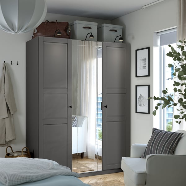 Modern bedroom with large grey PAX wardrobe, mirrored doors, and white decor.