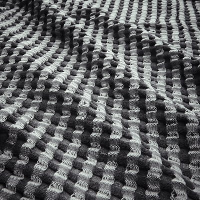Black and white waffle-weave cotton blanket; reversible, soft, and textured.