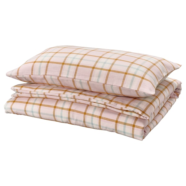 Folded pink and beige chequered sheets and pillows, neatly stacked. Plaid pattern, made of 100% cotton.