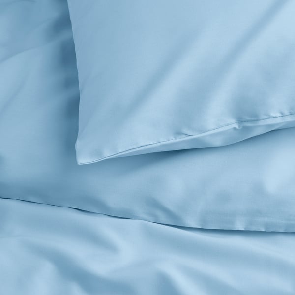 Light blue bedding set, smooth fabric, visible buttons, neatly arranged.
