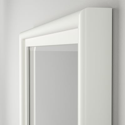 Close-up of PINGSTSYREN mirrors sleek, white, pine frame and clear glass with bevelled edges.