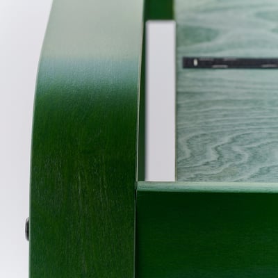 Close-up of durable green layered wood frames and soft, textured green fabric on POÄNG footstool.