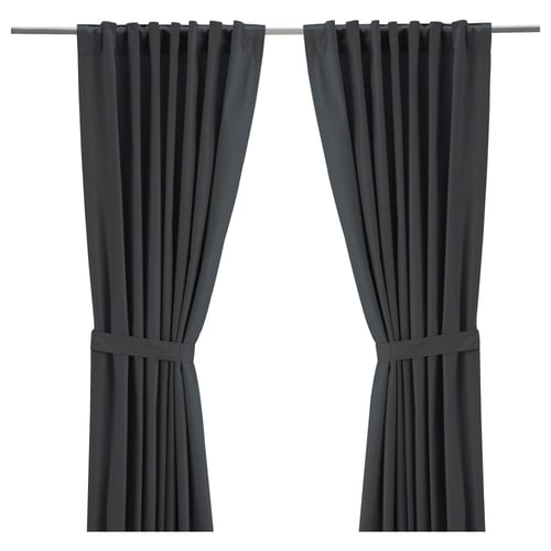 Two dark grey RITVA curtains hang straight with rod pockets and tiebacks. Made from 100% cotton, they provide privacy and light control.