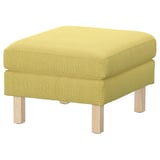 Bright green upholstered ottoman, square-shaped, with light wooden legs.