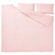 A light pink SCHERSMIN bedding set in organic cotton, designed with a soft, wavy texture and featuring a duvet cover and matching pillowcases.